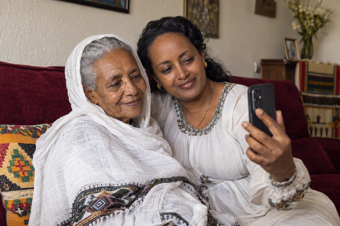 An older mother and her daughter share a phone call in their living room in Addis Ababa