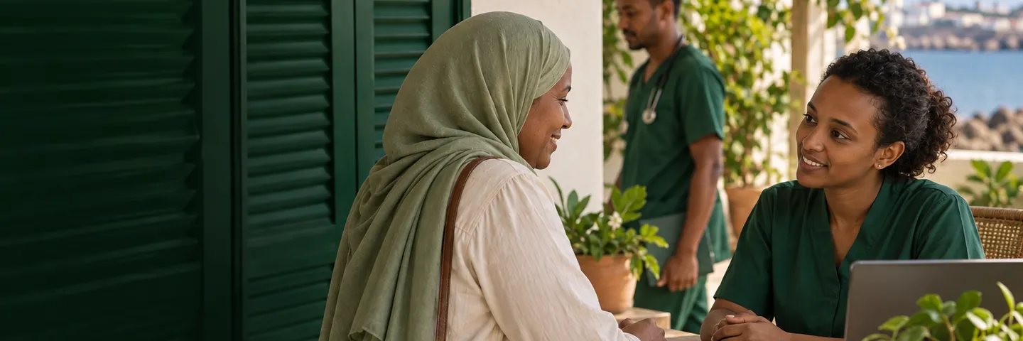 A patient is welcomed by a receptionist on a clinic terrace in Djibouti while a nurse walks past